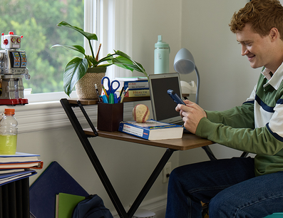 Male Student On Phone at Desk