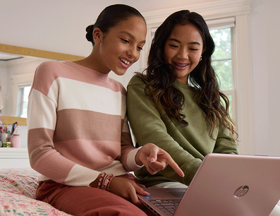 Two teenager girls browsing on a laptop