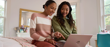 Two teenager girls browsing on a laptop